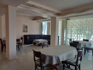 a dining room with tables and chairs and a couch at Интернационал in Kulata