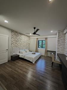 a bedroom with a bed and a stone wall at Cosy Designer's Home By The Mountain in Lumut