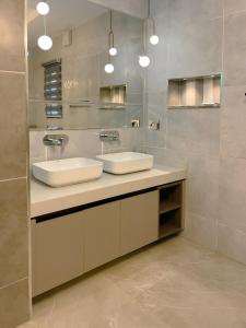 ein Badezimmer mit zwei Waschbecken und einem Spiegel in der Unterkunft Apartment in Jahi, Abuja in Jahi