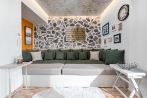a living room with a couch and a stone wall at Lous House in Agia Paraskevi