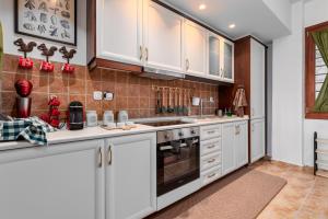 a kitchen with white cabinets and a sink at Lous House in Agia Paraskevi
