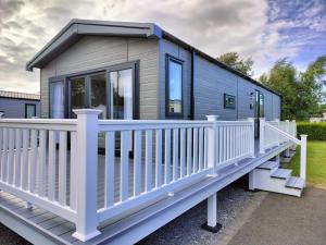 a tiny house with a white railing at Presthaven Resort 3 Bedroom Luxury Gold 2024 Caravan in Talacre