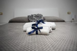 a pile of towels with blue bows on a bed at Villa Teresa in Maniago
