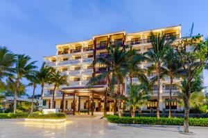 a hotel with palm trees in front of it at Wyndham Garden Hoi An Cua Dai Beach in Hoi An