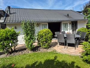 a house with a patio with a table and chairs at B&B Skitter-Rent in Zwaagdijk-Oost