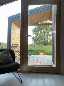 ein Wohnzimmer mit einer Glasschiebetür und einer Feuerstelle in der Unterkunft Tiny House an der Elbe Bleckede, Niedersachsen in Bleckede