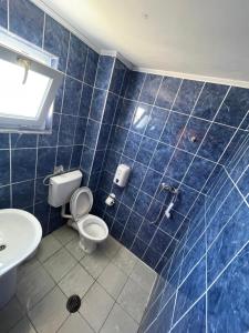 a blue tiled bathroom with a toilet and a sink at Hotel Capu' Turcului in Eforie Sud +47 photos