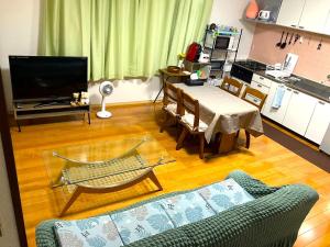 a living room with a couch and a table at 秋田ゲストハウス　BASE464 in Akita