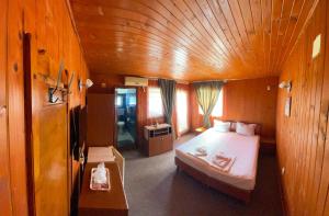 a bedroom with a bed in a wooden room at Hotel Capu' Turcului in Eforie Sud