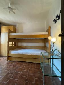 una camera con 2 letti a castello e un tavolo in vetro di Vista sul Blu - Costa Smeralda a Cala Bitta Altre 16 foto