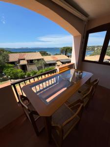 un tavolo e sedie su un balcone con vista di Vista sul Blu - Costa Smeralda a Cala Bitta