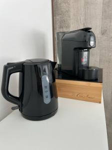 a black coffee maker sitting on a wooden stand at Aqua Marine B&B - Rooms and Apartments in Milazzo