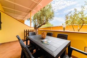 a table and chairs on the balcony of a house at Villaggio Residence Pietra Grigia in Marina di Camerota +44 photos