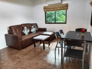 a living room with a couch and a table at Phratamnak Inn Hotel & Guesthouse - 100 mtr from the beach in Pattaya South