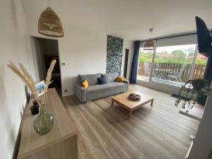a living room with a couch and a coffee table at Appartement Pour 6 Personne- Residence San Michele in Hossegor
