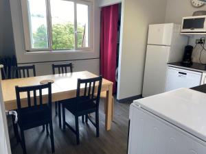 a kitchen with a table and chairs and a refrigerator at Appartement Pour 6 Personne- Residence San Michele in Hossegor
