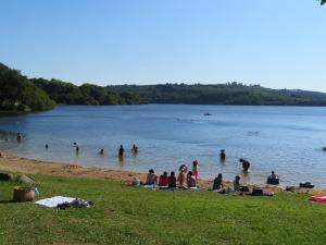 a group of people in the water at a beach at Camping Au Lac Du Drennec Glamping Tent in Commana