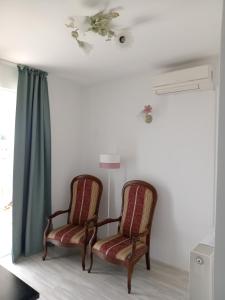 two chairs sitting in a room with a window at Ana Rooms in Krk