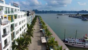 a view of a river with buildings and palm trees at Anson Condotel in Ha Long +4 photos