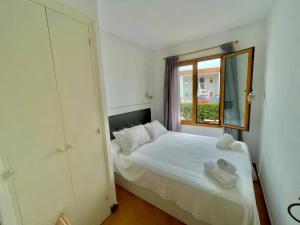 a bedroom with a bed with a mirror and a window at Llevant - Apartamento en planta baja con piscina in Arenal d'en Castell +28 photos