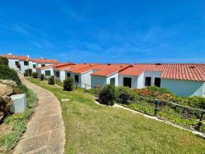 a row of houses with red roofs on a hill at Llevant - Apartamento en planta baja con piscina in Arenal d'en Castell
