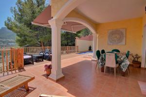 patio z łukiem, stołem i krzesłami w obiekcie Casa Felicidad w mieście Calpe