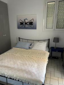 a bedroom with a bed with a white comforter and two windows at Lovely sea apartment Amarynthos in Amarinthos
