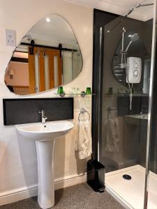 a bathroom with a sink and a shower with a mirror at Henwick house accommodation, Continental breakfast included in Ludlow +5 photos