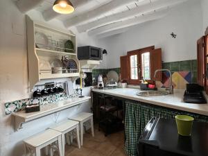 a kitchen with a counter and some chairs in it at Las casillas de la Villa: SOLEÁ in Montefrío