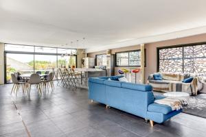 salon z niebieską kanapą i stołem w obiekcie Le Couvent des Ursulines - Penthouse climatisé piscine w mieście Narbona