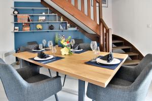 a dining room with a wooden table and chairs at Duplex Plancoët - Pour 4p à 15 min de la plage in Plancoët