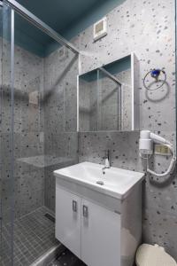 un bagno con un lavandino bianco e una doccia di Luxury Suite Studio City Centre a Tirana