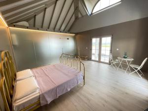 a bedroom with a bed and a table and a window at Căsuța Mov de Bucovina in Suceava