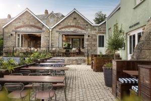 a patio with tables and chairs in front of a building at Pier House in St Austell