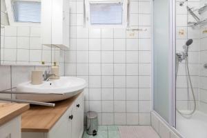 Un baño blanco con lavabo y ducha. en Apartments Maria, en Šilo