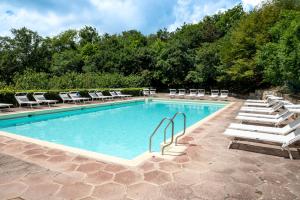 a swimming pool with chaise lounges and chairs at Hotel Monteconero in Sirolo