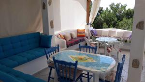 a patio with a couch and tables and chairs at Kocheilas Studios in Gialiskari