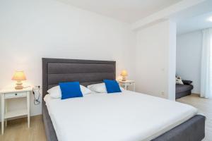 a bedroom with a large white bed with blue pillows at Kate's Perfect Family Villa in Elaphiti in Šipanska Luka +45 photos