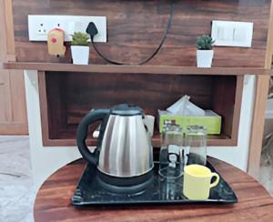 a tea kettle and cups on a table at MK Luxe in Nellore