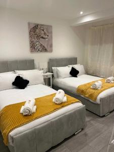 Un dormitorio con dos camas con toallas encima. en JB Stays Therapia, en Hackbridge