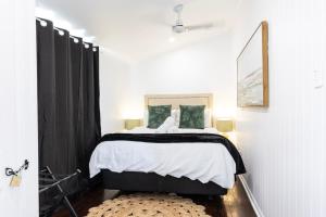 a bedroom with a bed with black curtains and a rug at Urban Getaway Central Cottage in Ipswich