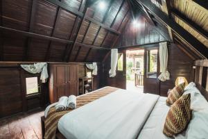 a bedroom with a large bed in a room with wooden walls at Sandat Bali Villa Canggu in Canggu +32 photos