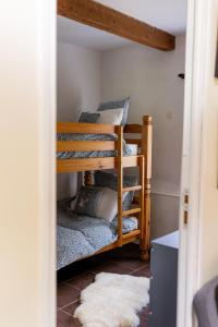 two bunk beds in a room with a rug at Gites Libellule at Auberge de l'Arac, Bar, Restaurant in Aleu