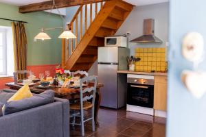 a kitchen and dining room with a table and refrigerator at Gites Libellule at Auberge de l'Arac, Bar, Restaurant in Aleu