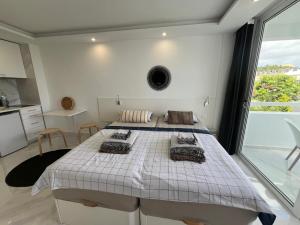 two beds in a room with a large window at Tenerife sea view 216 in Playa Fañabe