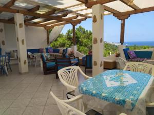 a patio with tables and chairs and a view of the ocean at Kocheilas Studios in Gialiskari