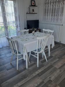 a white table with chairs and wine glasses on it at Apartman Neda in Sveti Ivan Dobrinjski