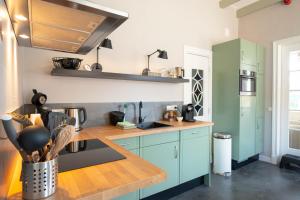a kitchen with blue cabinets and a wooden counter top at Thuis in Eenrum in Eenrum