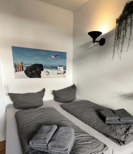 a bedroom with two beds with pillows and a picture on the wall at Hund im Glück in Wangerooge