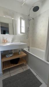 a bathroom with a sink and a tub and a mirror at Lanas Natura in Moliets-et-Maa